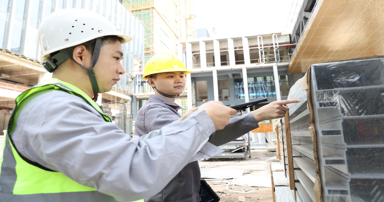 Workers using an Arrvel rugged tablet for inventory management and material verification at a construction site.
