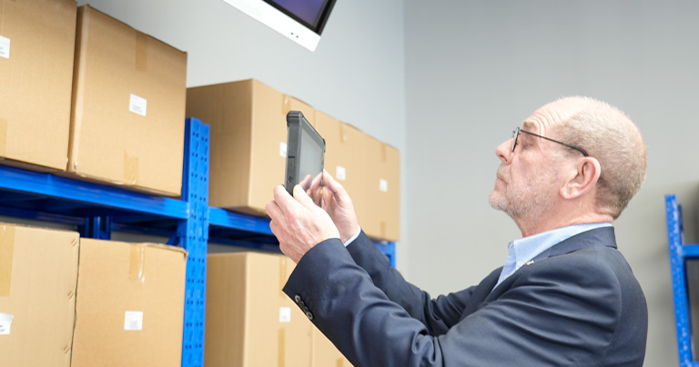 Heavy-duty industrial tablet PC for scanning QR codes in modern logistics warehouses for inventory tracking.