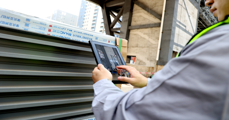 Warehouse worker using an Arrvel rugged tablet for inventory management and stock inspection.