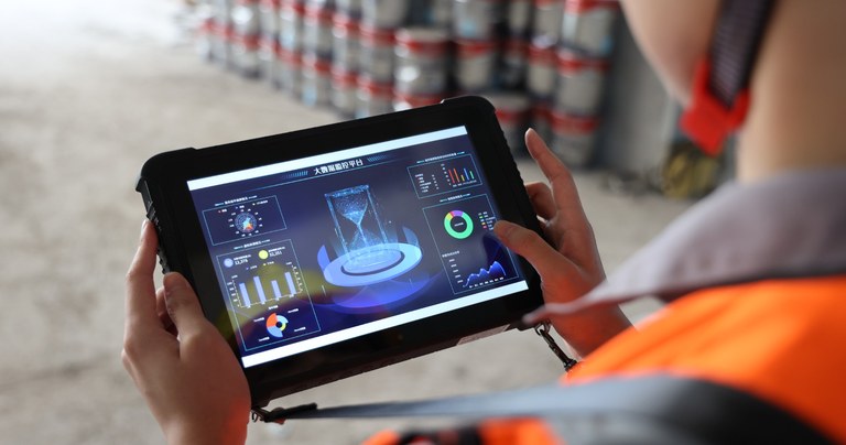Construction worker using a rugged tablet for field project monitoring and data management