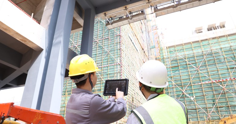 Construction workers using a rugged tablet to review project information on site
