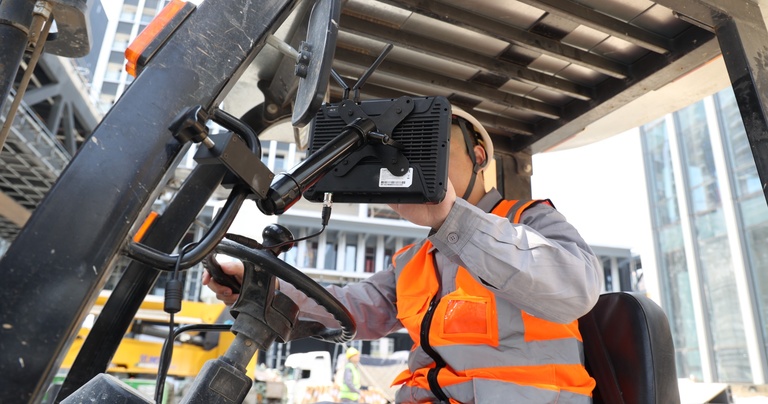 Rugged forklift mounted tablet with industrial mounting bracket installed inside a warehouse forklift.