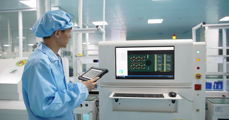 Factory operator monitoring PCB production and quality control using an Arrvel industrial rugged tablet.