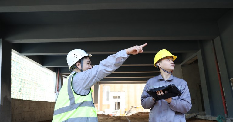 Construction workers using a rugged tablet for on-site inspection and field coordination
