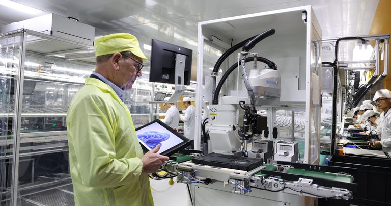 Factory engineer using a rugged tablet for smart manufacturing, equipment monitoring and industrial automation.