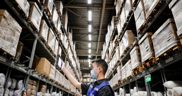 Warehouse employee using a rugged tablet for barcode scanning and inventory checking