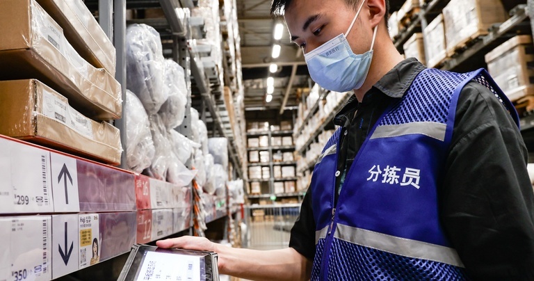Warehouse worker using a rugged tablet for inventory management and stock verification